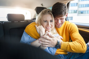 Lächelndes, verliebtes Paar auf dem Rücksitz eines Autos - DIGF000842