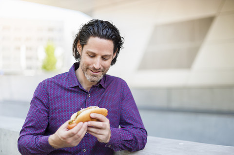 Modischer Geschäftsmann mit Hot Dog, lizenzfreies Stockfoto
