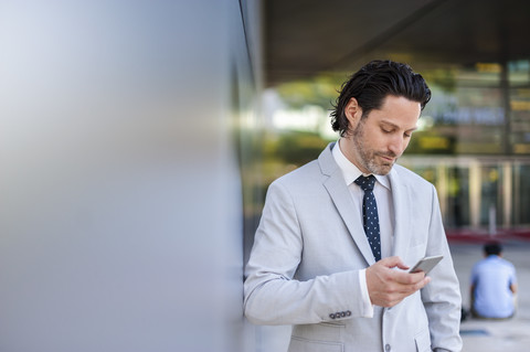 Geschäftsmann schaut auf Smartphone, lizenzfreies Stockfoto