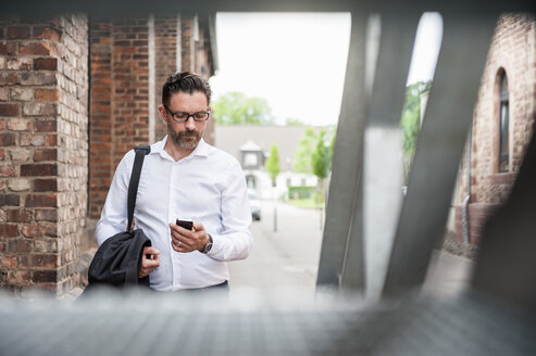 Geschäftsmann schaut auf sein Handy - DIGF000923