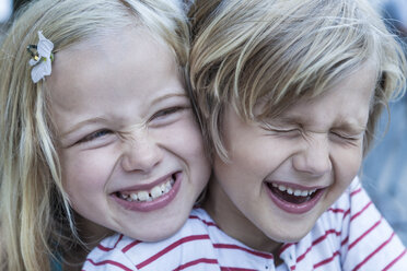 Porträt eines lachenden kleinen Jungen und seiner Schwester Kopf an Kopf - TCF005054