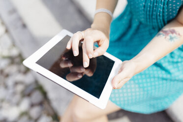 Hands of young woman using tablet - GIOF001353