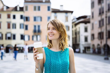 Porträt einer lächelnden jungen Frau mit Kaffee zum Mitnehmen - GIOF001356