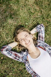 Portrait of smiling young woman relaxing on a meadow - GIOF001362