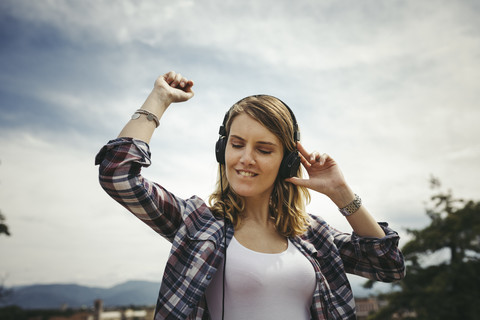 Junge Frau hört Musik mit Kopfhörern, lizenzfreies Stockfoto