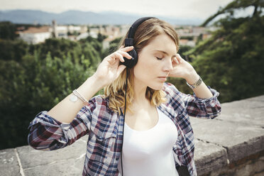 Young woman listening music with headphones - GIOF001372