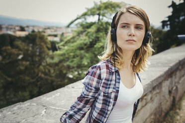 Young woman listening music with headphones - GIOF001373
