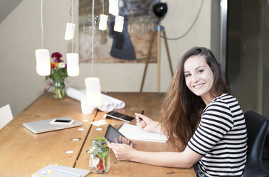 Portrait of smiling young woman using digital tablet - REAF000103