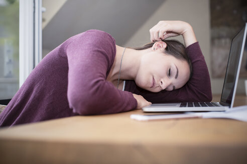 Tired young woman sleeping at desk - REAF000119