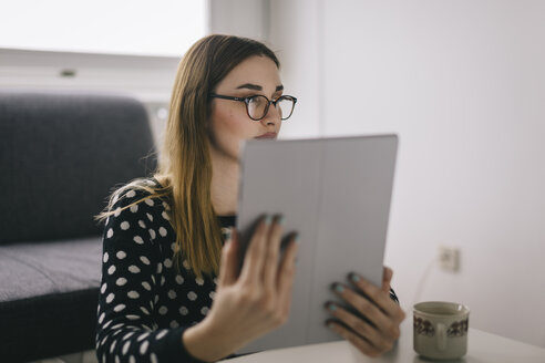 Junge Frau benutzt Tablet zu Hause - LCUF000041