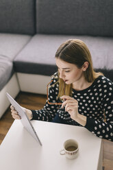 Young woman using tablet at home - LCUF000042