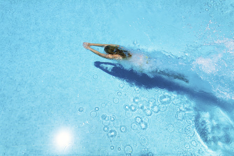 Frau taucht im Schwimmbad unter Wasser, lizenzfreies Stockfoto