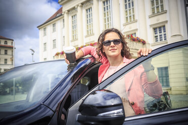 Porträt einer Frau mit Sonnenbrille, die in ihr Auto steigt - VTF000546