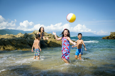 Mutter und drei Kinder spielen mit Strandball - ABAF002067