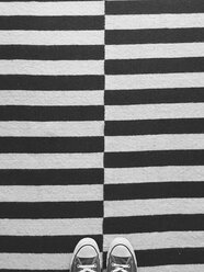Turnschuhe auf einem schwarz-weißen Teppich - GIOF001378