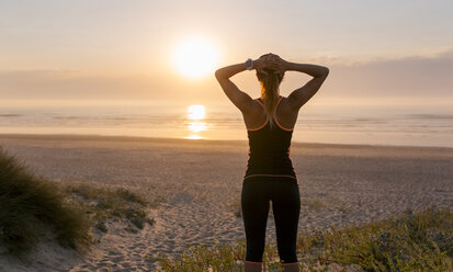 Spain, Aviles, young athlete woman enjoying the sunset on the beach - MGOF002140