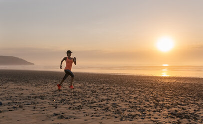 Sportler Frau läuft am Strand bei Sonnenuntergang - MGOF002142