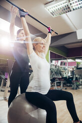 Schwangere Frau macht Übungen im Fitnessstudio - ZEDF000263