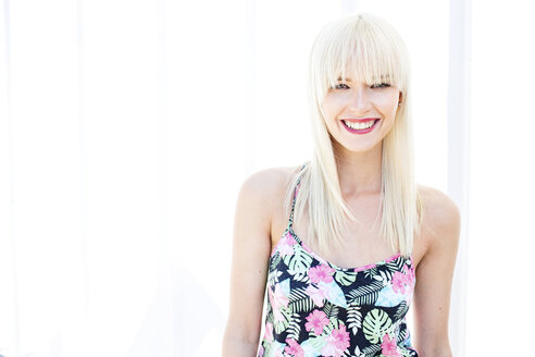 Porträt einer lächelnden blonden Frau vor einem hellen Hintergrund - GDF001086