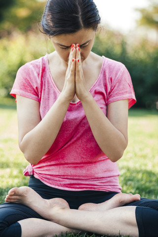 Young woman doing yoga, meditation outside, eyes closed stock photo