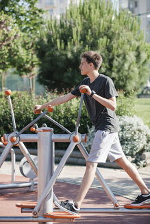 Teenager beim Training an einem Outdoor-Fitnessgerät - BZF000335