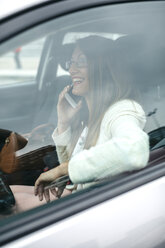 Smiling businesswoman on cell phone in car - DAPF000212