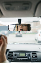 Woman in car applying lipstick - DAPF000214