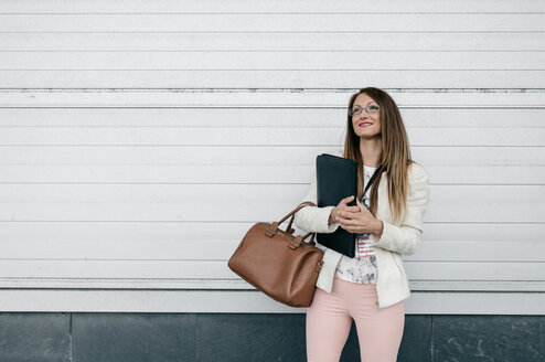 Lächelnde Geschäftsfrau mit Handtasche und Ordner im Freien - DAPF000242