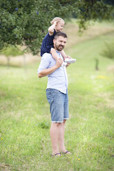 Happy father carrying little daughter on shoulders in nature - HAPF000694