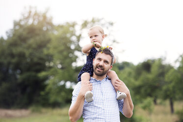 Happy father carrying little daughter on shoulders in nature - HAPF000695