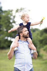 Father carrying little daughter on shoulders in nature - HAPF000696