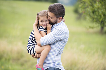 Father holding daughter in his arms - HAPF000698