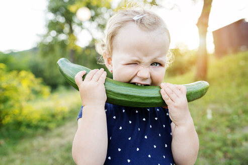 Portrait of little girl biting in cucumber - HAPF000709