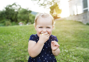 Porträt eines kleinen blonden Mädchens, das Gebäck isst - HAPF000710