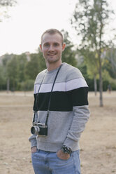 Portrait of smiling man with vintage camera - SKCF000153