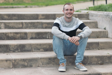 Porträt eines lächelnden Mannes auf einer Treppe sitzend - SKCF000156