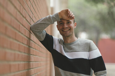 Portrait of smiling man at brick wall - SKCF000157