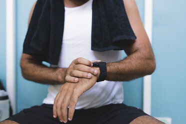 Close-up of athlete with smartwatch outdoors - FMOF000078