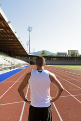 Young sportsman standing on tartan track - FMOF000079