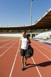 Young sportsman walking on tartan track - FMOF000083