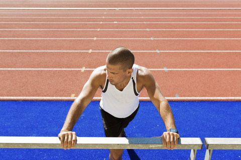 Young sportsman stretching, railing stock photo