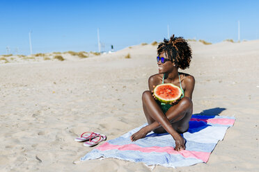 Glückliche junge Frau mit Wassermelone am Strand - KIJF000627
