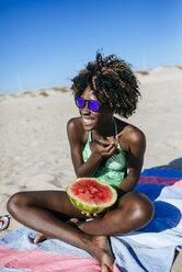Glückliche junge Frau mit Wassermelone am Strand - KIJF000629