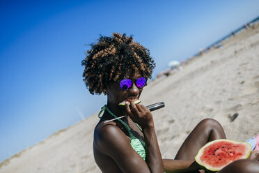 Junge Frau isst Wassermelone am Strand - KIJF000630