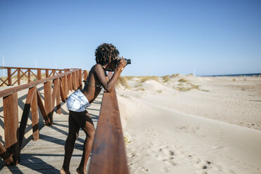 Junge Frau beim Fotografieren am Strand - KIJF000651