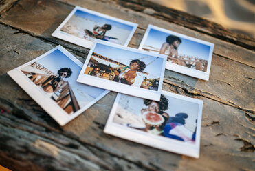 Instant photos of young woman on wooden table - KIJF000680
