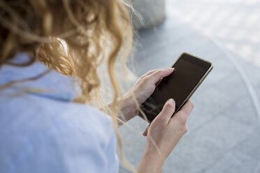 Businesswoman checking cell phone outdoors - MAUF000680