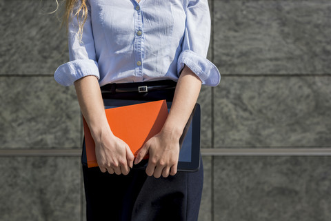 Geschäftsfrau hält Buch und digitales Tablet im Freien, lizenzfreies Stockfoto
