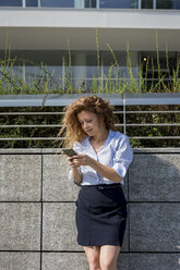 Businesswoman using cell phone outdoors - MAUF000685