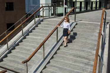 Businesswomanwalking downstairs outdoors - MAUF000694